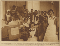 871112 Afbeelding van een groep verpleegsters en patiënten rond het versierde bed van een jarige patiënt in het ...